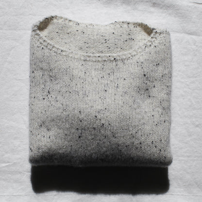 The Summer Soft jersey is folded neatly on a white linen table cloth. The light is shining softly from the top.