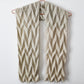 An Ups and Downs scarf hanging from a hanger against a neutral background. The shadows from the side make the 3D fabric stand out